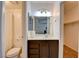 Well-lit bathroom featuring a vanity with a dark wood base, a large mirror, and a toilet with shower in background at 2696 Matogroso Ln, Las Vegas, NV 89121