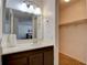 Well-lit bathroom featuring a vanity with a dark wood base, a large mirror, and a view of the closet at 2696 Matogroso Ln, Las Vegas, NV 89121
