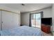 Bright bedroom featuring sliding glass doors, neutral tones and a comfortable bed with a blue patterned comforter at 2696 Matogroso Ln, Las Vegas, NV 89121