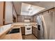 Efficient kitchen layout with stainless steel appliances, light countertop, and dark stained cabinetry at 2696 Matogroso Ln, Las Vegas, NV 89121