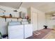 Spacious laundry room with washer, dryer, shelves, and concrete floors at 2696 Matogroso Ln, Las Vegas, NV 89121