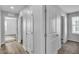 Hallway featuring wood-look floors and neutral paint, leading to carpeted bedrooms and natural light at 2832 Aragon Terrace Way, Henderson, NV 89044