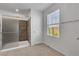 Bathroom with a glass shower, a bright window, and light tile flooring at 2832 Aragon Terrace Way, Henderson, NV 89044