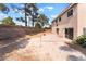 The backyard offers a concrete patio, a block wall fence, rock landscaping, and mature trees offering plenty of shade at 2874 Avanti Ln, Henderson, NV 89074