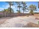 Large backyard featuring a concrete patio, mature trees, and a block wall fence providing privacy at 2874 Avanti Ln, Henderson, NV 89074