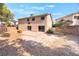 A backyard with a concrete patio area, two-story home, and a basketball hoop above one of the sliding glass doors at 2874 Avanti Ln, Henderson, NV 89074