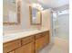 Bathroom with dual sinks, wood cabinets, a shower and tub combo, and decorative mirrors at 2874 Avanti Ln, Henderson, NV 89074