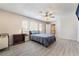 Spacious bedroom features plank floors, multiple windows, ceiling fan, and light-colored walls at 2874 Avanti Ln, Henderson, NV 89074