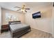 Bedroom featuring wood-look flooring, ceiling fan, and a mounted TV at 2874 Avanti Ln, Henderson, NV 89074