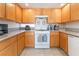 Well-lit kitchen with granite countertops, oak cabinets, and white appliances at 2874 Avanti Ln, Henderson, NV 89074