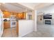 Open kitchen view showcasing white appliances, tile floors, and a view to the living room at 2874 Avanti Ln, Henderson, NV 89074