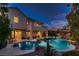 Home exterior overlooking a backyard pool with rock features, palms and tiki bar at 3042 Hammerwood Dr, Las Vegas, NV 89135