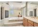Bright bathroom with a soaking tub, glass block details, and dual sinks at 3042 Hammerwood Dr, Las Vegas, NV 89135