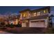 Elegant home featuring a spacious three-car garage, stone accents, and a second-story balcony at dusk at 3042 Hammerwood Dr, Las Vegas, NV 89135