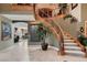 Grand foyer with elegant staircase and lush potted tree, creating a stunning first impression at 3042 Hammerwood Dr, Las Vegas, NV 89135