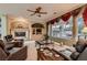 Relaxing living room is decorated with a fireplace and windows overlooking the outdoor living space at 3042 Hammerwood Dr, Las Vegas, NV 89135