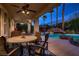 Covered patio with dining table, backyard pool and tiki hut at 3042 Hammerwood Dr, Las Vegas, NV 89135