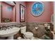 Stylish powder room featuring decorative tile, a round accent window, and elegant fixtures at 3042 Hammerwood Dr, Las Vegas, NV 89135