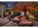 An inviting tiki bar with a thatched roof creates a tropical oasis for relaxed outdoor entertaining at 3042 Hammerwood Dr, Las Vegas, NV 89135