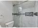 Glass shower in a bathroom with decorative tiled accent and modern fixtures at 3192 Tullio Way, Henderson, NV 89052