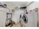 Efficient laundry room featuring a washer, dryer, storage shelves, and tile flooring at 3192 Tullio Way, Henderson, NV 89052