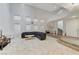 Spacious living room with spiral staircase, tile floors, and a large leather sectional sofa at 3192 Tullio Way, Henderson, NV 89052