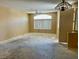 The living room features a ceiling fan, a large window, and no floor covering at 3261 Monaco Shores Dr, Las Vegas, NV 89117