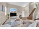 Open concept living room with a vaulted ceiling, wood staircase, and a large TV at 3659 Gerri Bay Ln, Las Vegas, NV 89147
