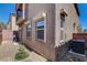 Stucco home exterior with rock landscaping, windows, and a grill, surrounded by a brick privacy wall at 3839 Zodiacal Light St, Las Vegas, NV 89129