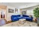 Bright living room with blue sofa, artistic portraits, and decorative houseplant at 3839 Zodiacal Light St, Las Vegas, NV 89129