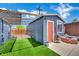 Charming backyard building with artificial grass, a brick-lined fishpond, and overhead string lights at 4419 Lorna Pl, Las Vegas, NV 89107