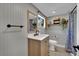 Bright bathroom features wood vanity, framed mirror, and open shelving for storage at 4419 Lorna Pl, Las Vegas, NV 89107