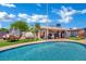 Backyard oasis featuring a sparkling pool, covered patio, and lush landscaping for relaxation at 4419 Lorna Pl, Las Vegas, NV 89107