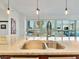 Modern kitchen island with barstool seating, stainless steel sink, and city views beyond the dining area at 4471 Dean Martin Dr # 1109, Las Vegas, NV 89103