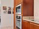 Modern kitchen with stainless steel microwave, oven and cherry wood cabinets, alongside unique wall art at 4471 Dean Martin Dr # 1109, Las Vegas, NV 89103