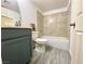 Well-lit bathroom with a shower-tub combo, gray vanity, and neutral tiling at 4682 Leeann Ln, Las Vegas, NV 89121