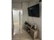 Hallway with tiled floors, multiple doors, and a console with a TV on the wall at 5353 Hollow Brook Ave, Las Vegas, NV 89142