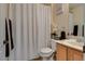 Cozy bathroom featuring a shower with white curtain, wooden vanity, and neutral decor at 5712 French Lace Ct, North Las Vegas, NV 89081