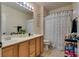 Bathroom showcasing double sinks, a framed mirror, and a shower tub combination with a curtain at 5712 French Lace Ct, North Las Vegas, NV 89081