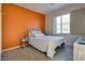 Cozy bedroom with a bed, side tables, modern lamps, and orange accent wall at 5712 French Lace Ct, North Las Vegas, NV 89081