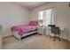 Bedroom with a bed, desk, and large window offering plenty of natural light at 5712 French Lace Ct, North Las Vegas, NV 89081