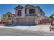 Two-story stucco home featuring a spacious three-car garage and wrought iron fence at 5712 French Lace Ct, North Las Vegas, NV 89081