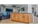 View of kitchen island with granite countertops and wooden cabinets leading to the living room at 5712 French Lace Ct, North Las Vegas, NV 89081