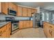 Spacious kitchen with stainless steel appliances, wooden cabinets, and tile flooring at 5712 French Lace Ct, North Las Vegas, NV 89081
