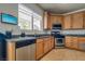 Well-lit kitchen showcasing wooden cabinets, stainless steel appliances, and a sink with a window view at 5712 French Lace Ct, North Las Vegas, NV 89081