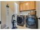 Well-equipped laundry room with modern washer and dryer, storage cabinets, and laundry schedule wall decor at 5712 French Lace Ct, North Las Vegas, NV 89081
