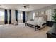 Spacious main bedroom with a large bed, sitting area, and multiple windows with dark drapes at 5712 French Lace Ct, North Las Vegas, NV 89081