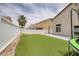 Fenced backyard with artificial grass, a concrete patio, and ample space for outdoor activities at 5816 Glory Canyon Way, Las Vegas, NV 89142