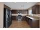 Well-lit kitchen with stainless steel appliances, wood-look floors, and granite countertops at 5816 Glory Canyon Way, Las Vegas, NV 89142