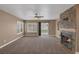 Bright living room features a fireplace, ceiling fan, carpet, and sliding glass door at 5816 Glory Canyon Way, Las Vegas, NV 89142